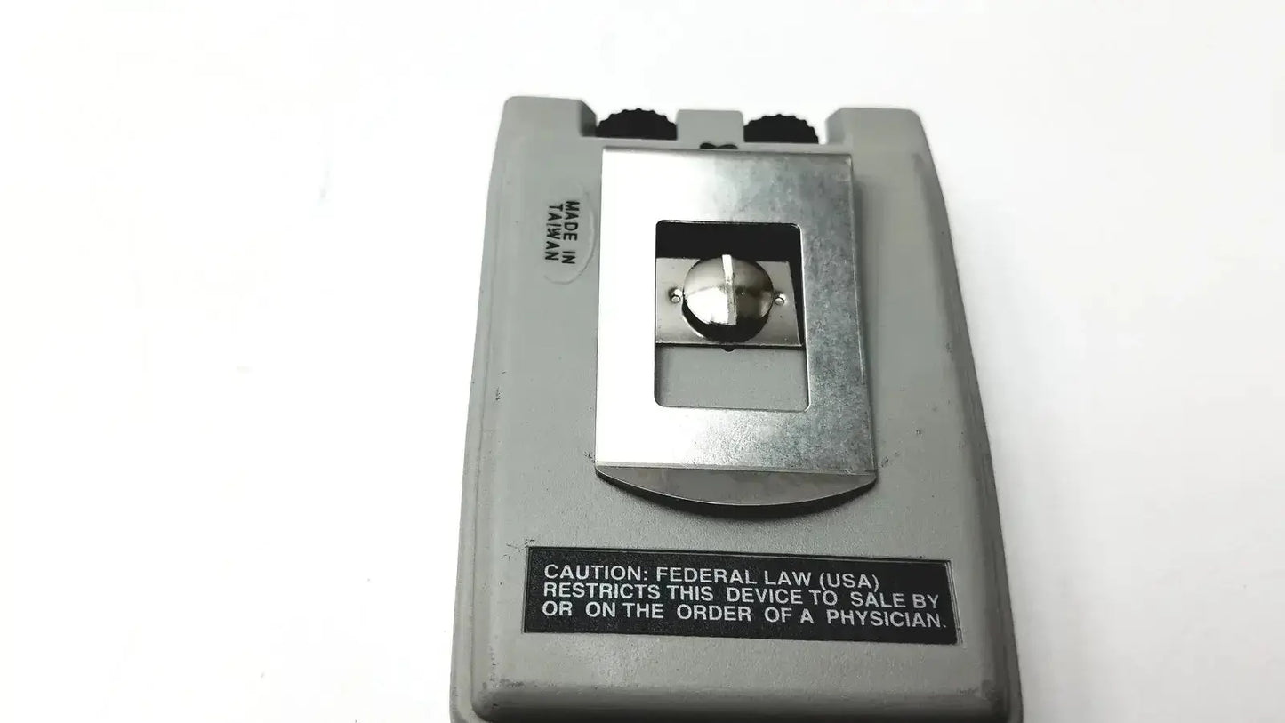 Gray plastic handheld biotens transcutaneous electrical nerve stimulator with metallic silver button insert