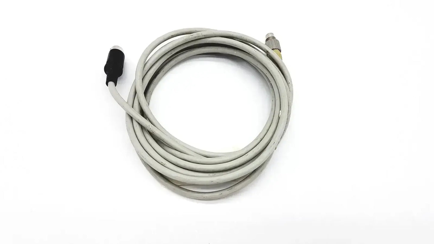 Gray coiled control techniques connecting cable with black and metallic connectors for industrial use