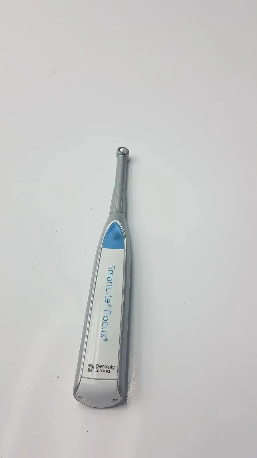 Silver and blue dentsply sirona smartlite focus dental curing light handpiece for efficient dental curing procedures