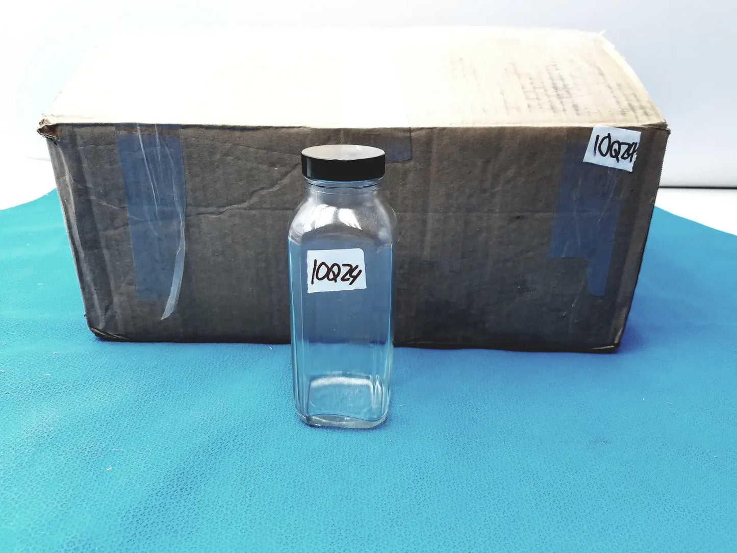 Glass Bottle with Black Cap Marked