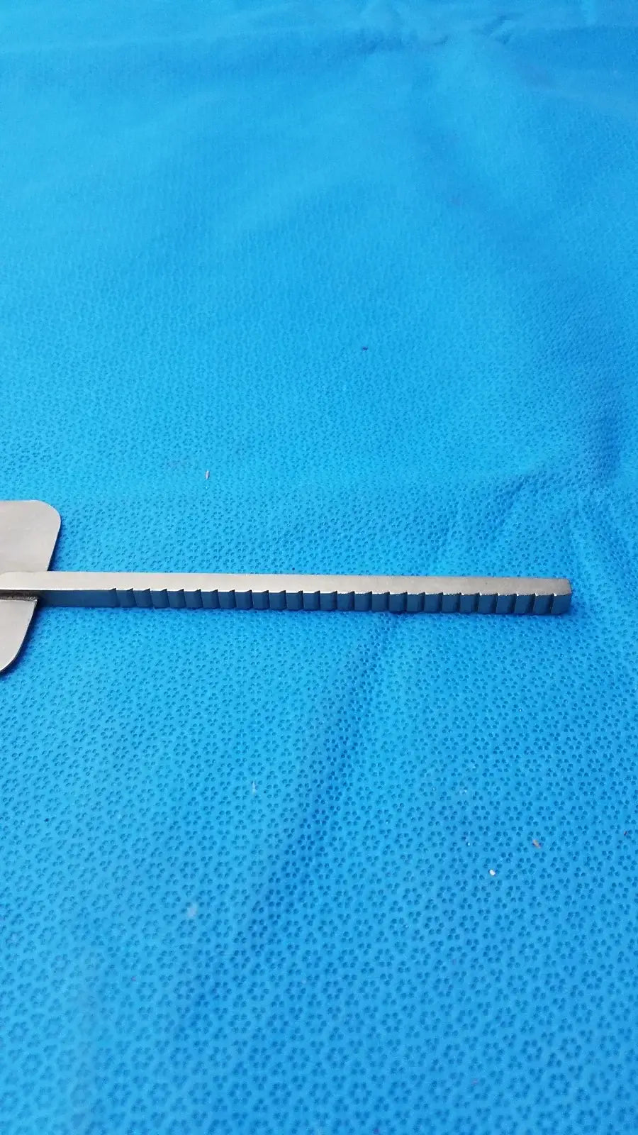 Silver stainless steel malleable retractor blade with flat handle and evenly spaced notches for reuse medical equipment