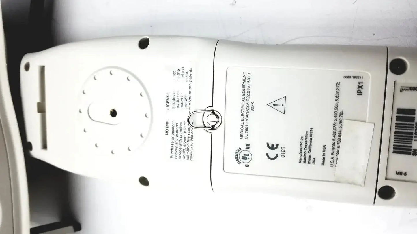 White plastic Masimo extraction pulse oximeter showing regulatory labels and certification markings on the back side
