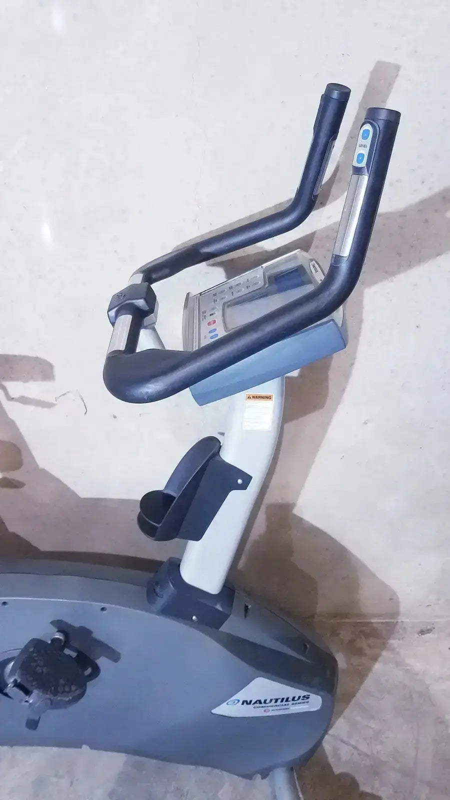 Gray and black nautilus schwinn blue indoor cycling bike with digital display panel on handlebars for commercial use