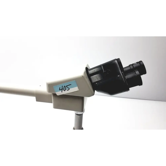 Black and beige compound microscope with a labeled ’405’’ sticker on its arm.