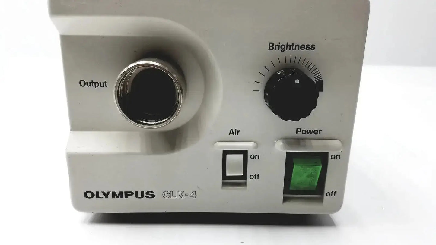 White olympus clk-4 dental halogen light source with metallic output port black brightness dial and green power indicator
