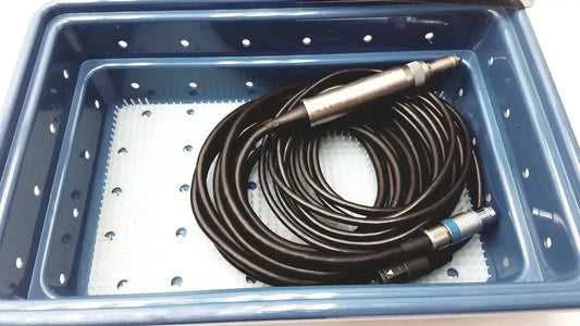 Coiled black cable with metallic connectors in blue storage tray of stryker 5400-277 core sterilization case