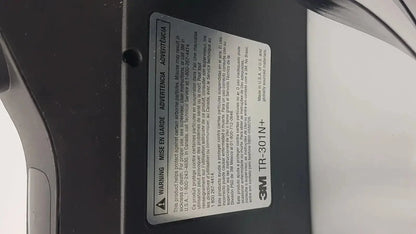 Black 3m versaflo tr-301n+ adhesive tape label with white text and warning symbol for tr-300n+ blower product