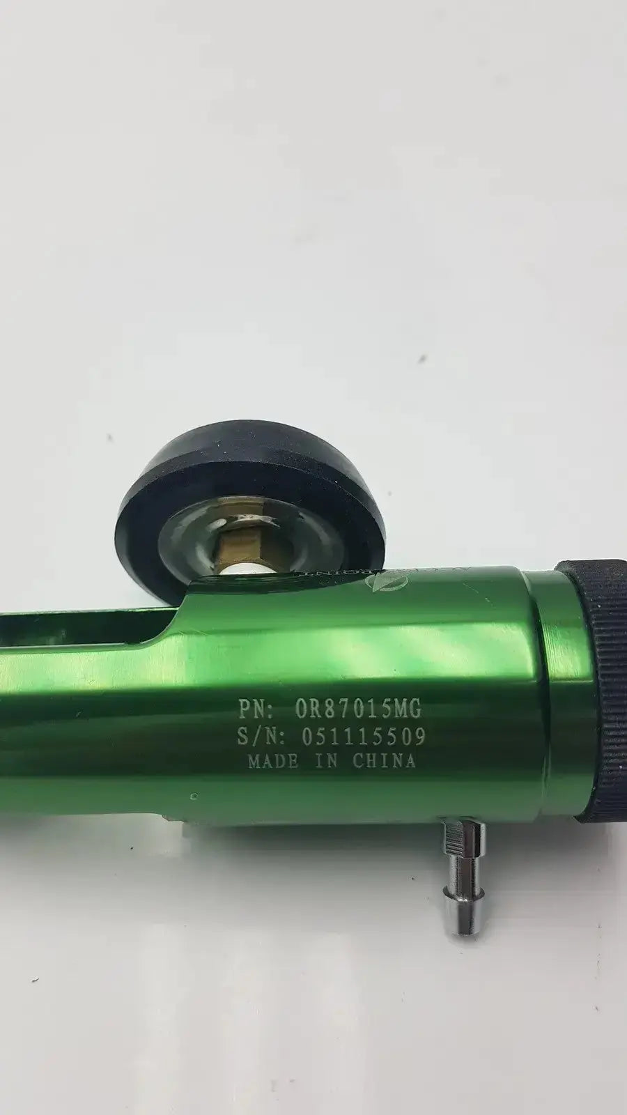 Green metallic air-powered impact wrench with black rubber grip and roller attachment for medical oxygen regulator use