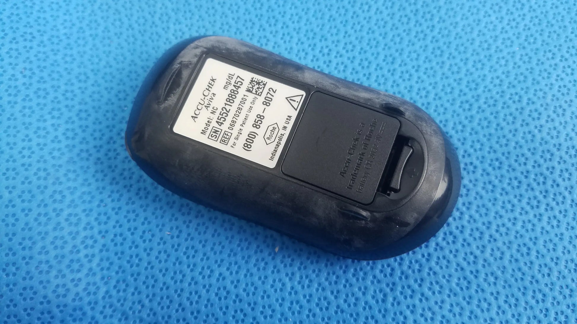 Black plastic Accu Chek Aviva blood glucose meter with matte finish and rounded edges for medical equipment use