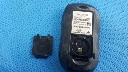 Black plastic accu chek aviva blood glucose meter back with battery compartment and label showing model and serial info