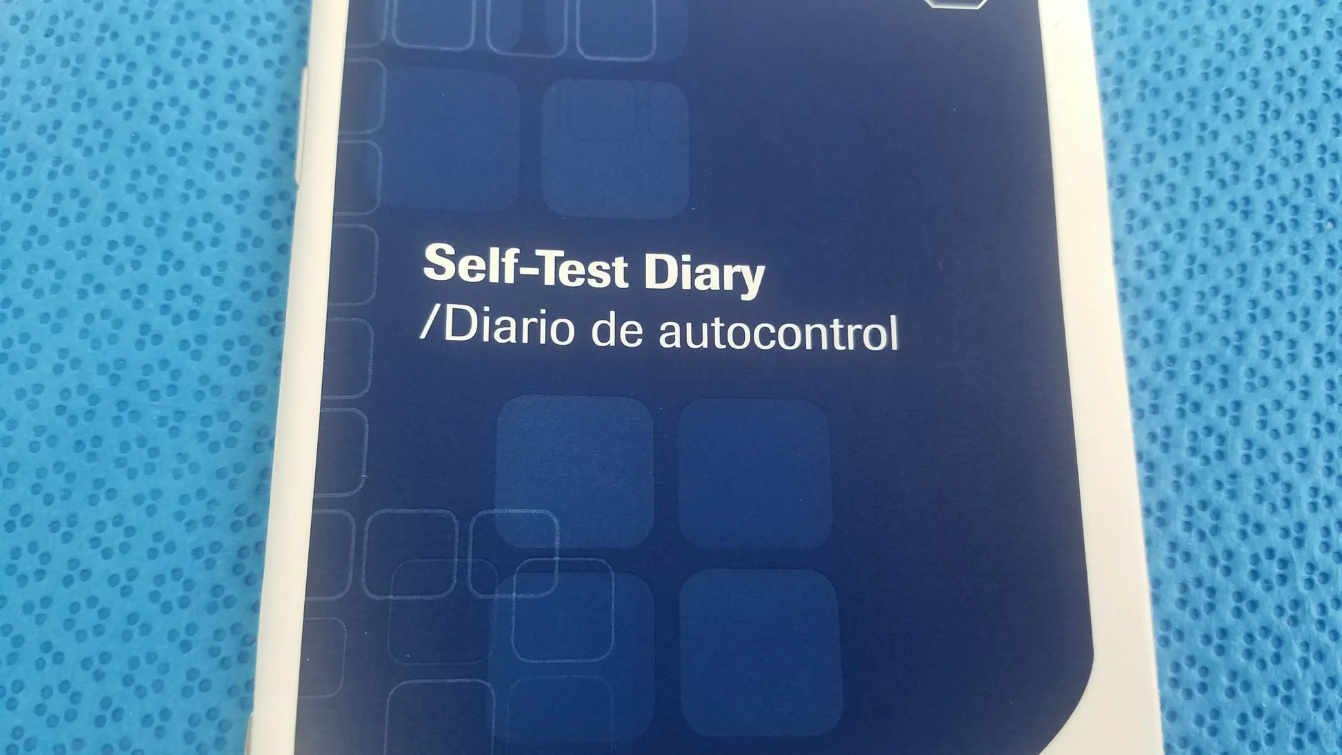 Blue and white self-test diary booklet with geometric design for aviva blood glucose medical equipment monitoring system bag