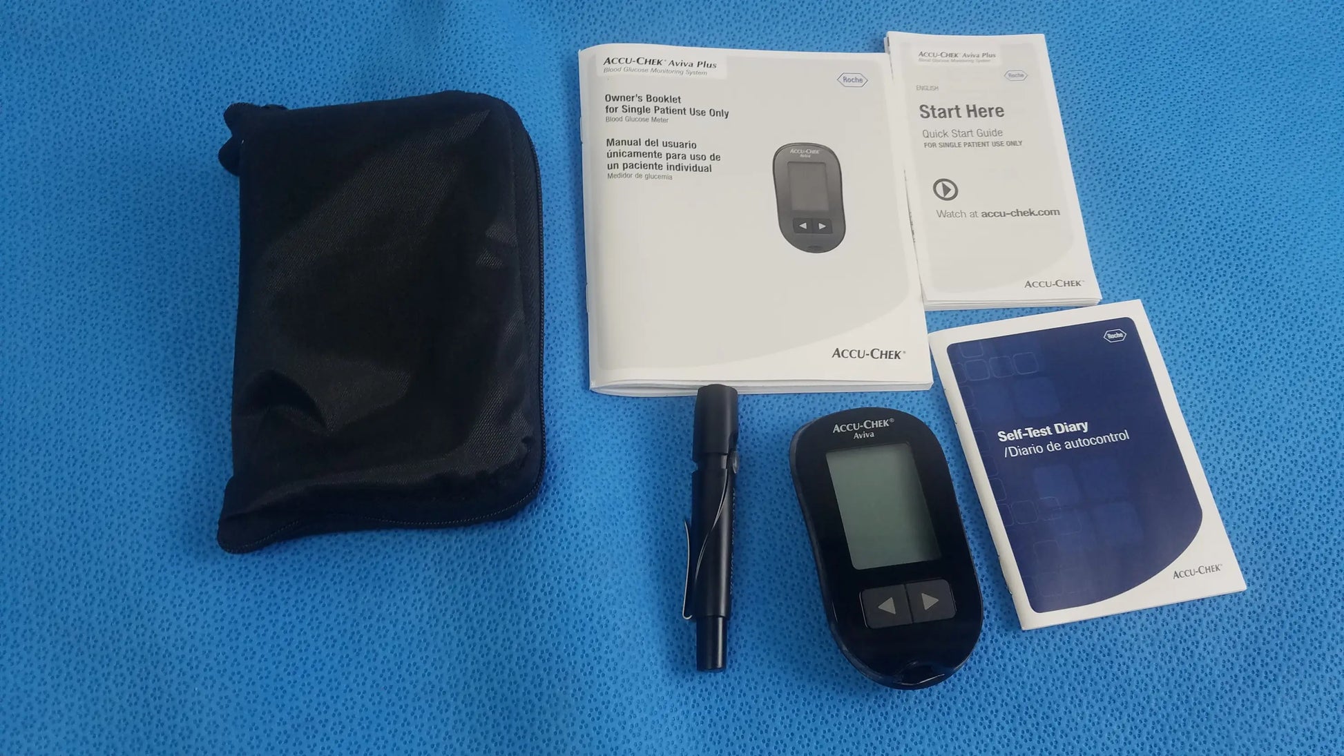 Black accu-chek aviva blood glucose meter with digital display and navigation buttons in medical equipment bag case
