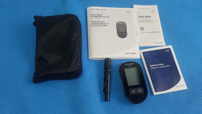 Black accu-chek aviva blood glucose meter with digital display and navigation buttons in medical equipment bag case