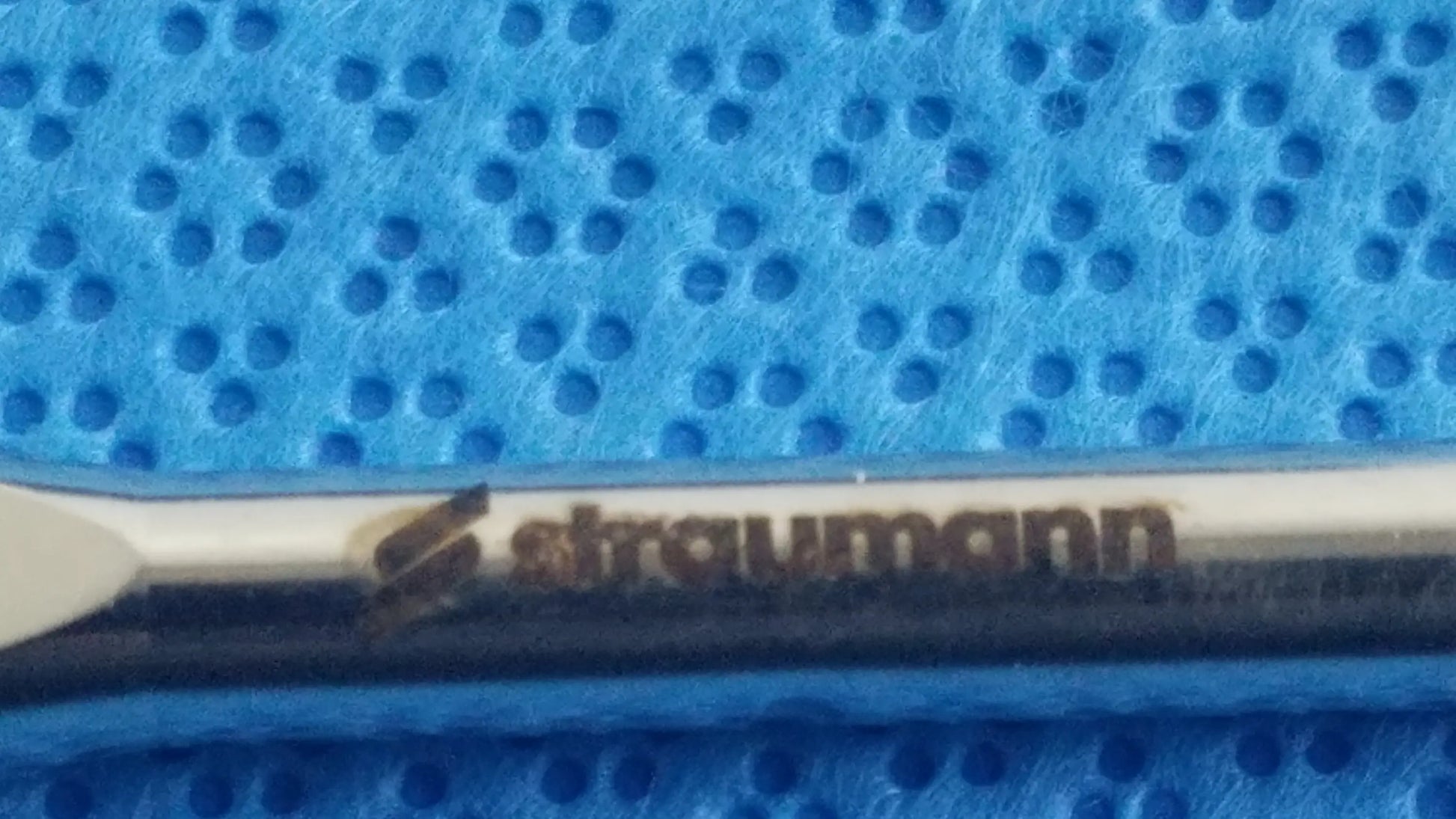 Silver-colored straumann dental implant screw with polished finish and branding in ace 765-1001 sterilization tray medical equipment