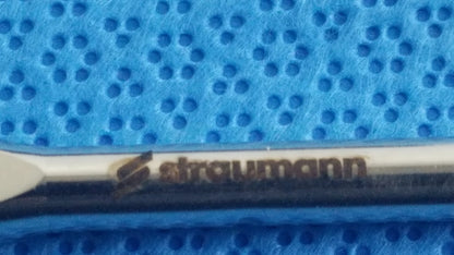 Silver-colored straumann dental implant screw with polished finish and branding in ace 765-1001 sterilization tray medical equipment