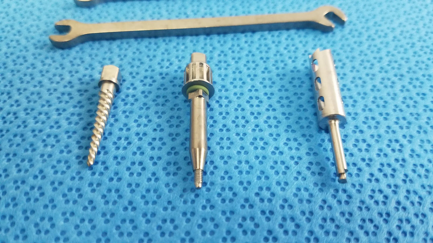Silver surgical drill bits and wrench on blue textured surface for ace ophthalmology micro surgery medical equipment