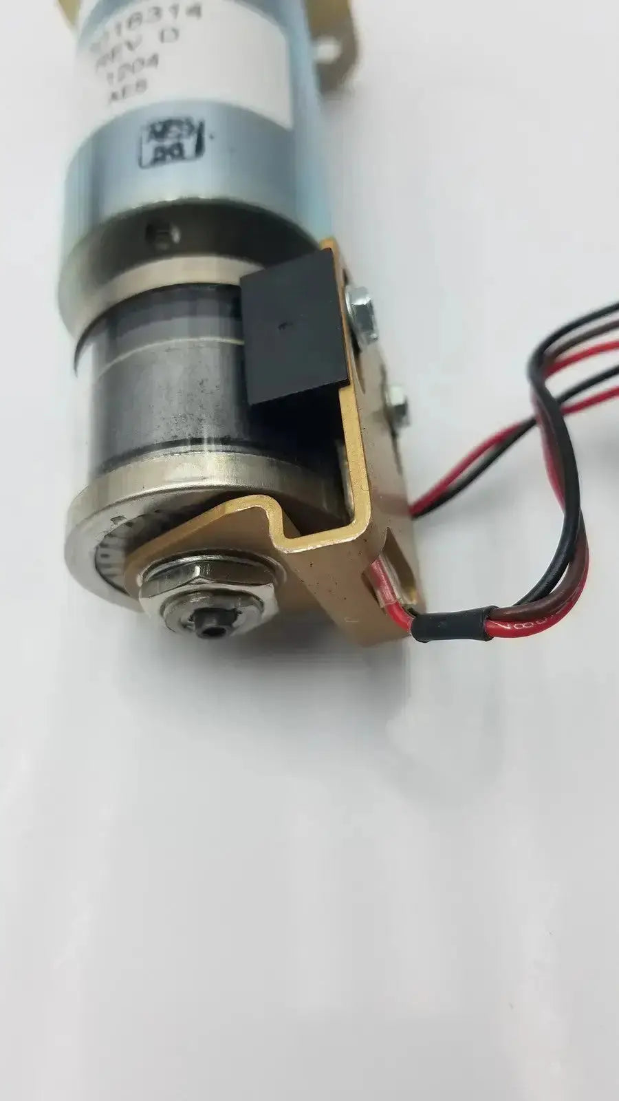 Silver and brass-colored acro associates 955v8669 rev a valve electric motor with black wiring and 12v dc label