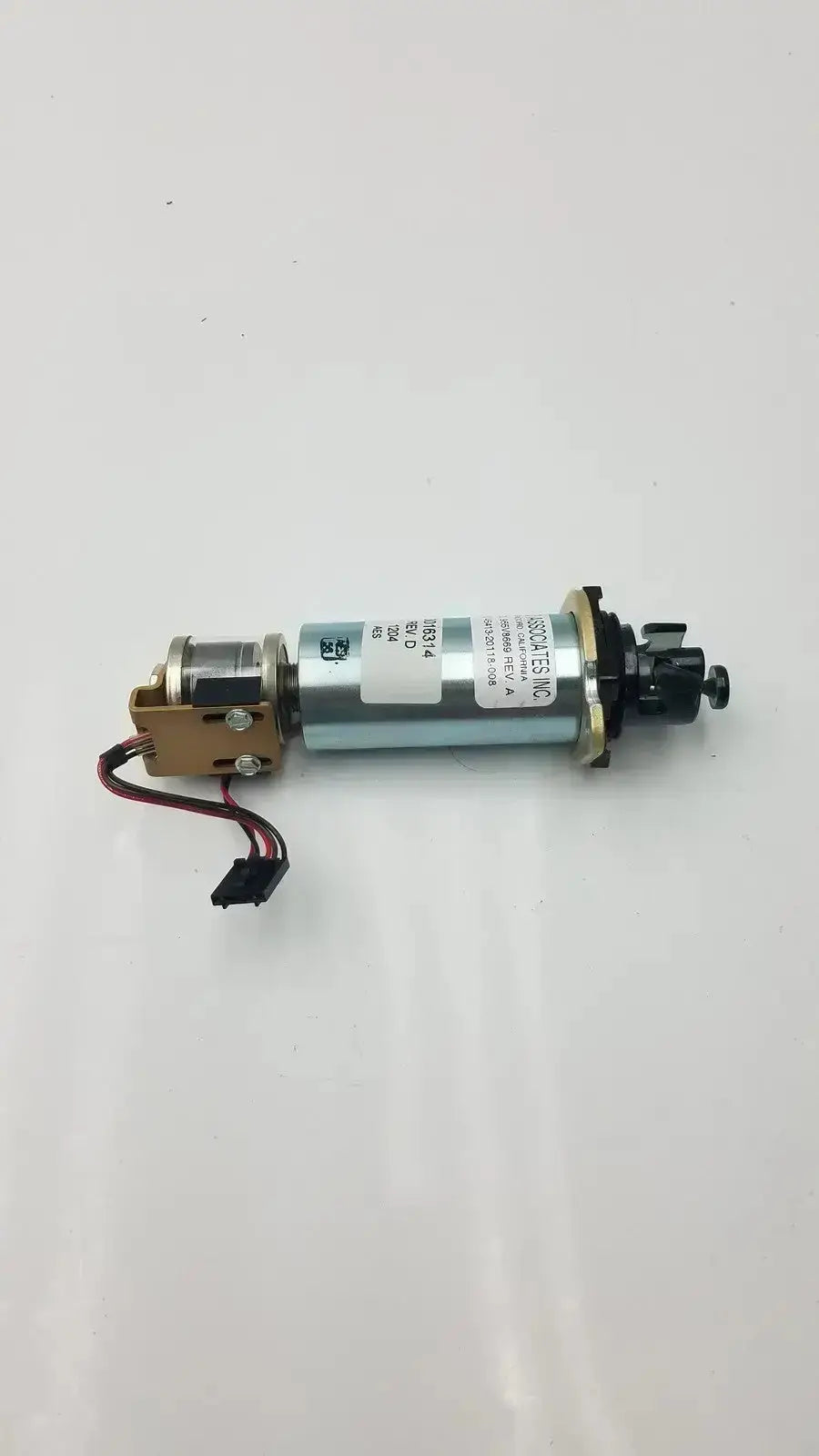 Silver cylindrical motor with black and gold components and label featuring technical specifications of acro associates 955v8669 rev a valve