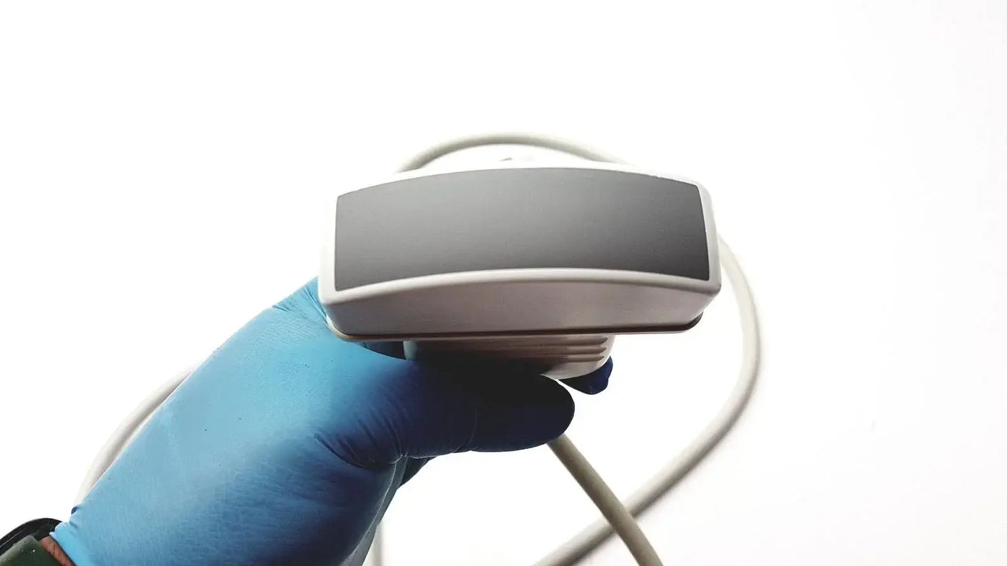 Silver-gray rectangular acuson c3 needle guide convex array ultrasound transducer probe held in blue-gloved hand medical equipment