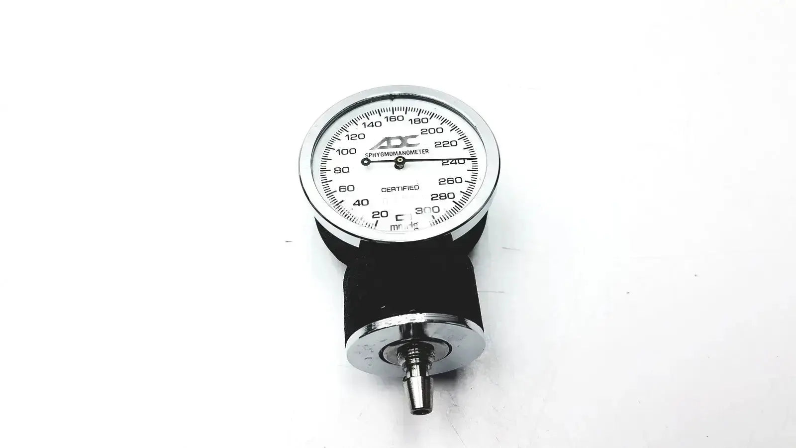 Silver and black aneroid sphygmomanometer manual gauge with chrome casing and rubber cuff for blood pressure monitoring
