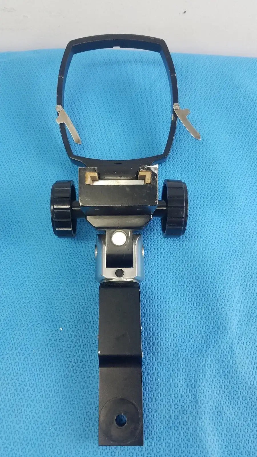 Black plastic adjustable flash gun bracket with two wheels and central hinge for reuse medical equipment applications
