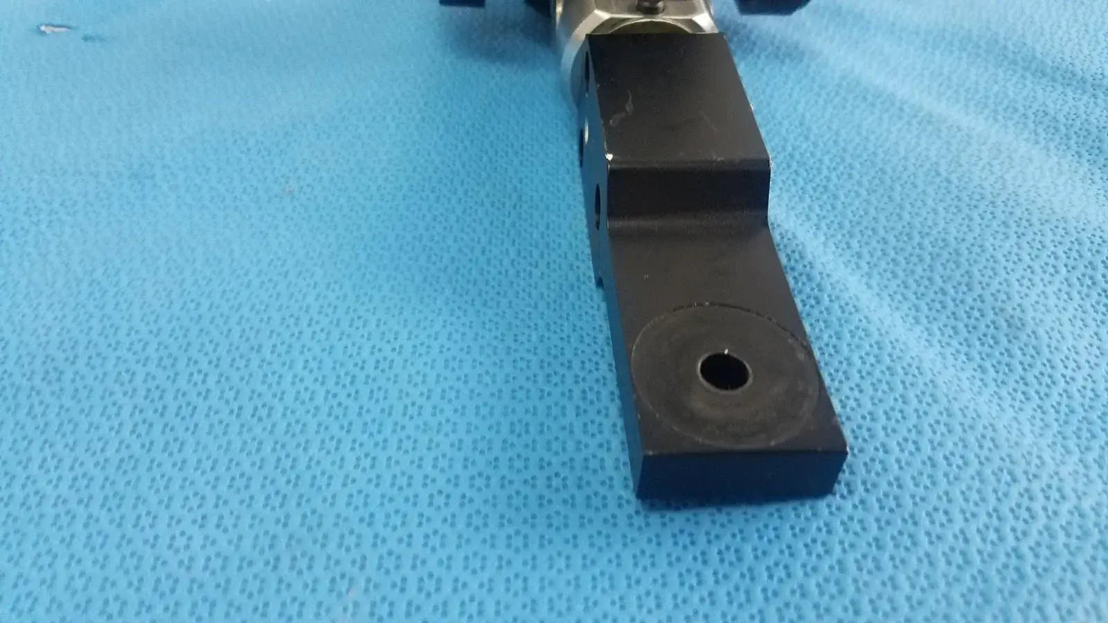 Black rectangular adjustable flash gun bracket with circular hole and metallic joint for reuse medical equipment mounting