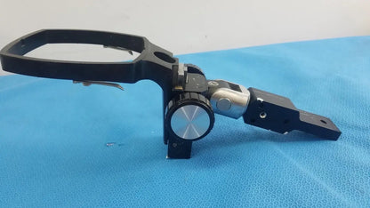Adjustable flash gun bracket with black and silver metal tripod head and circular dial for precise angle control
