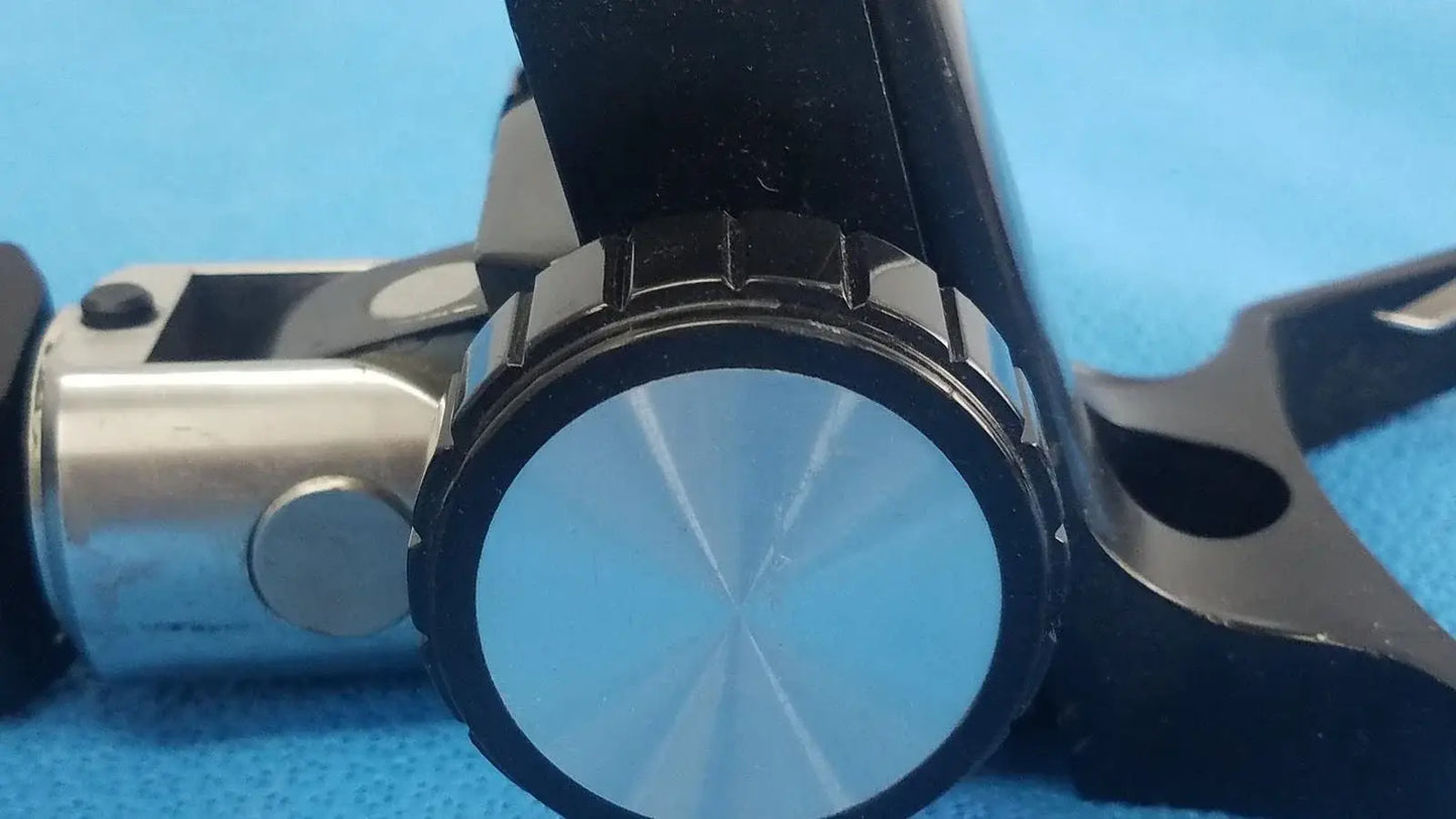 Adjustable flash gun bracket featuring black and silver magnifying glass with textured ribbed rim for medical equipment reuse