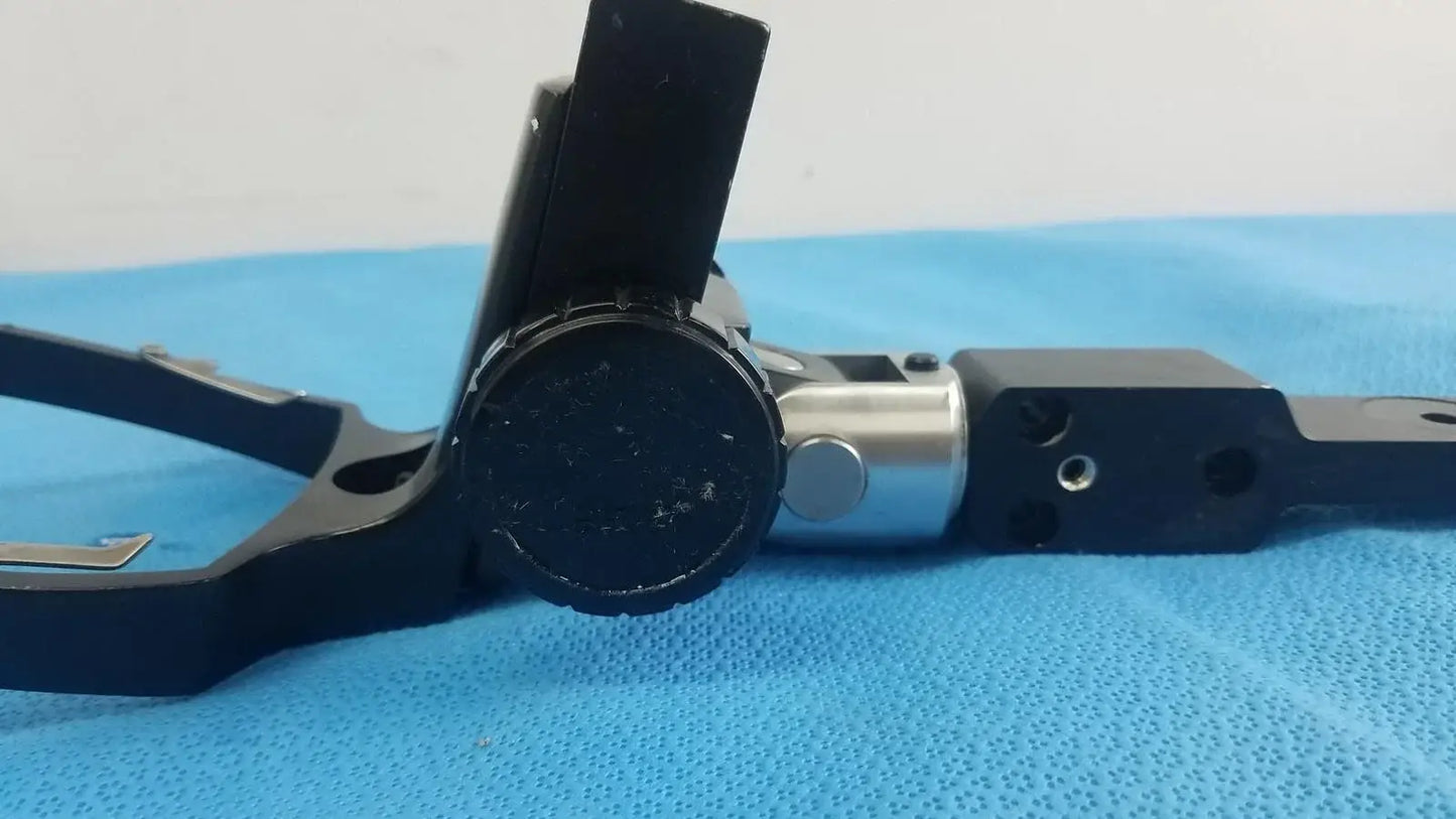 Black and silver mechanical adjustable flash gun bracket with circular knob and articulated arms for reuse medical equipment
