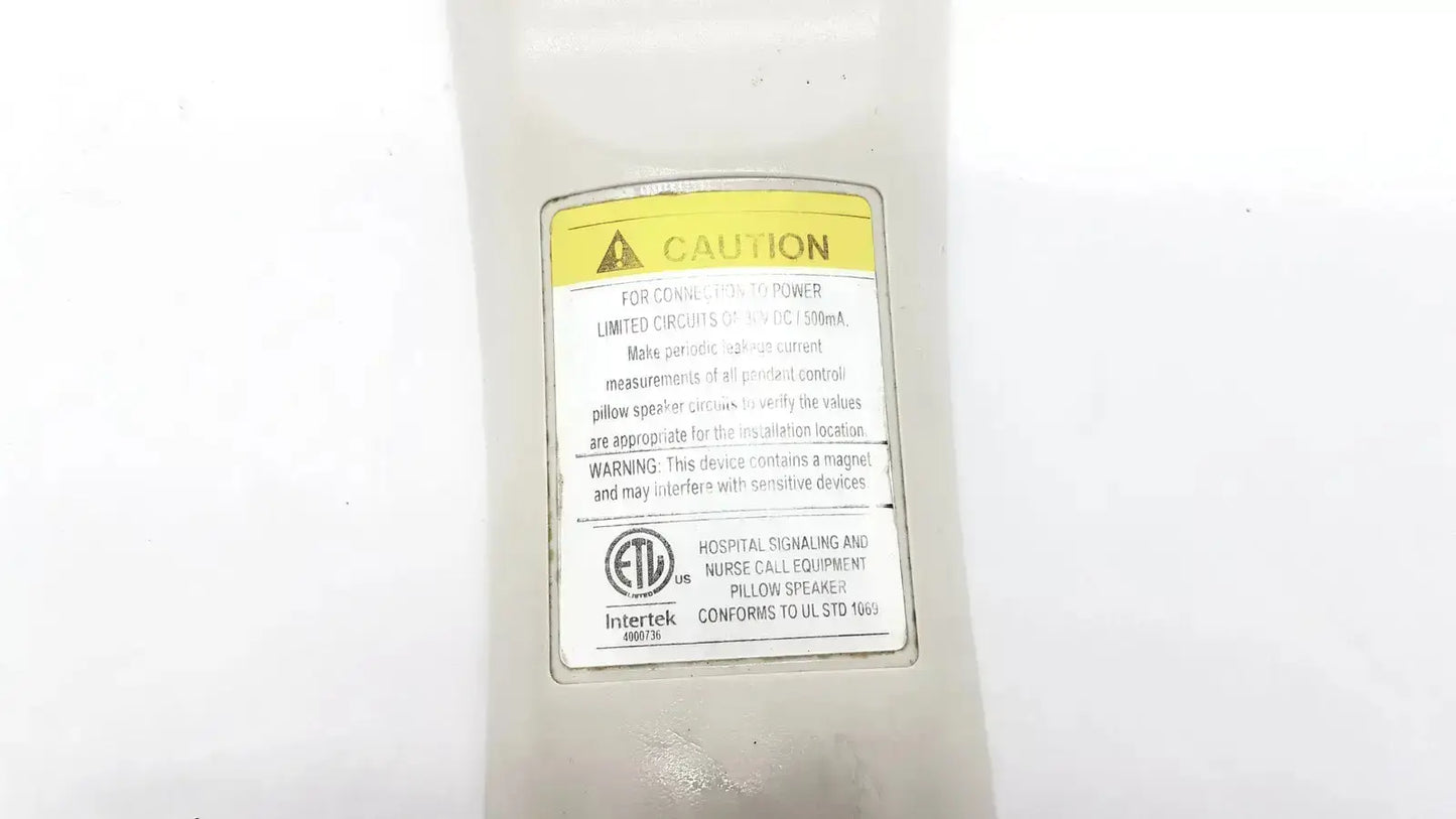 White plastic hospital signaling and nurse call pillow speaker with yellow caution label by Allen Technologies Curbell