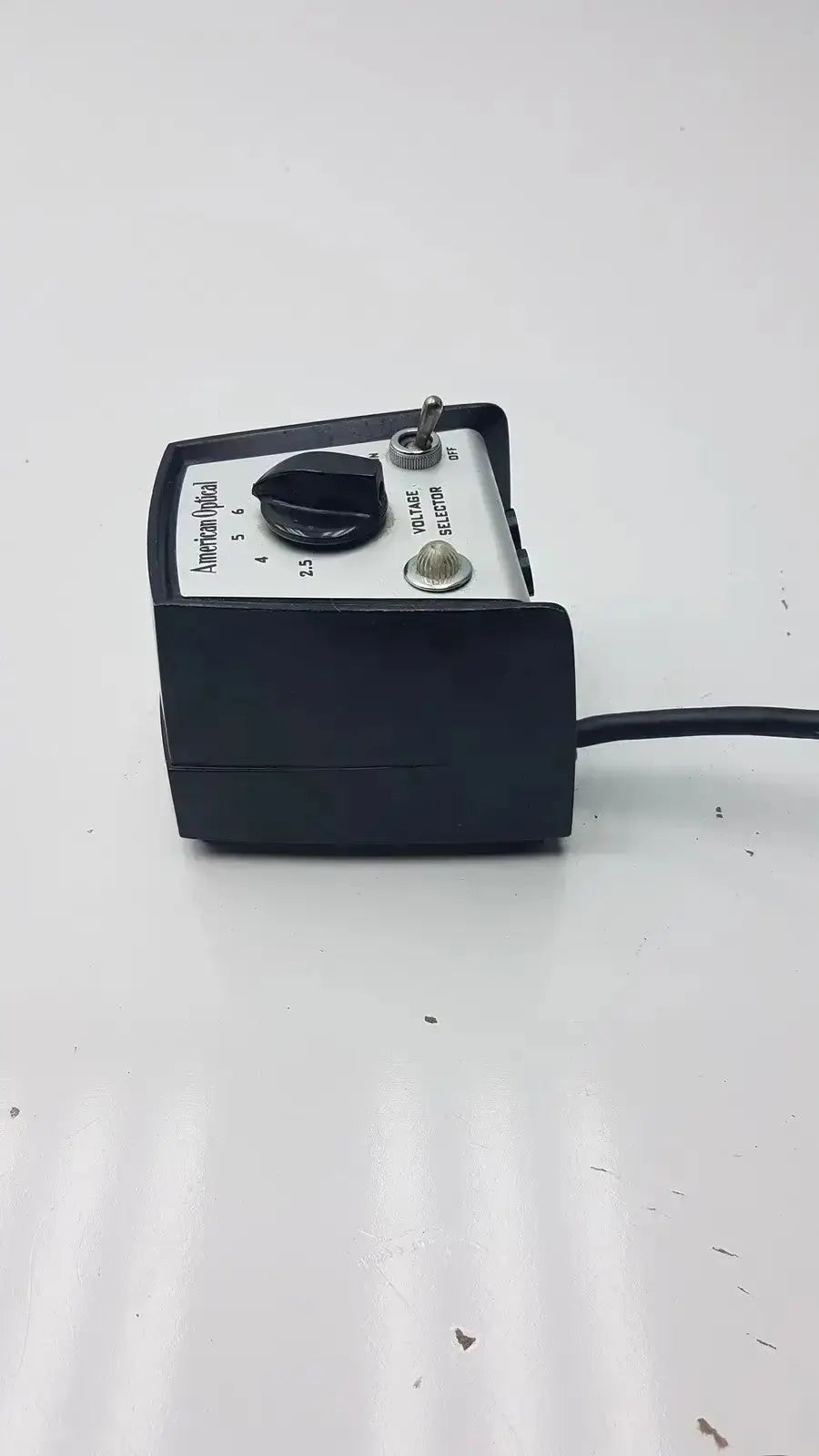 Black and silver American Optical 11144 voltage selector pri with rotary dial toggle switch and labeled settings made in USA