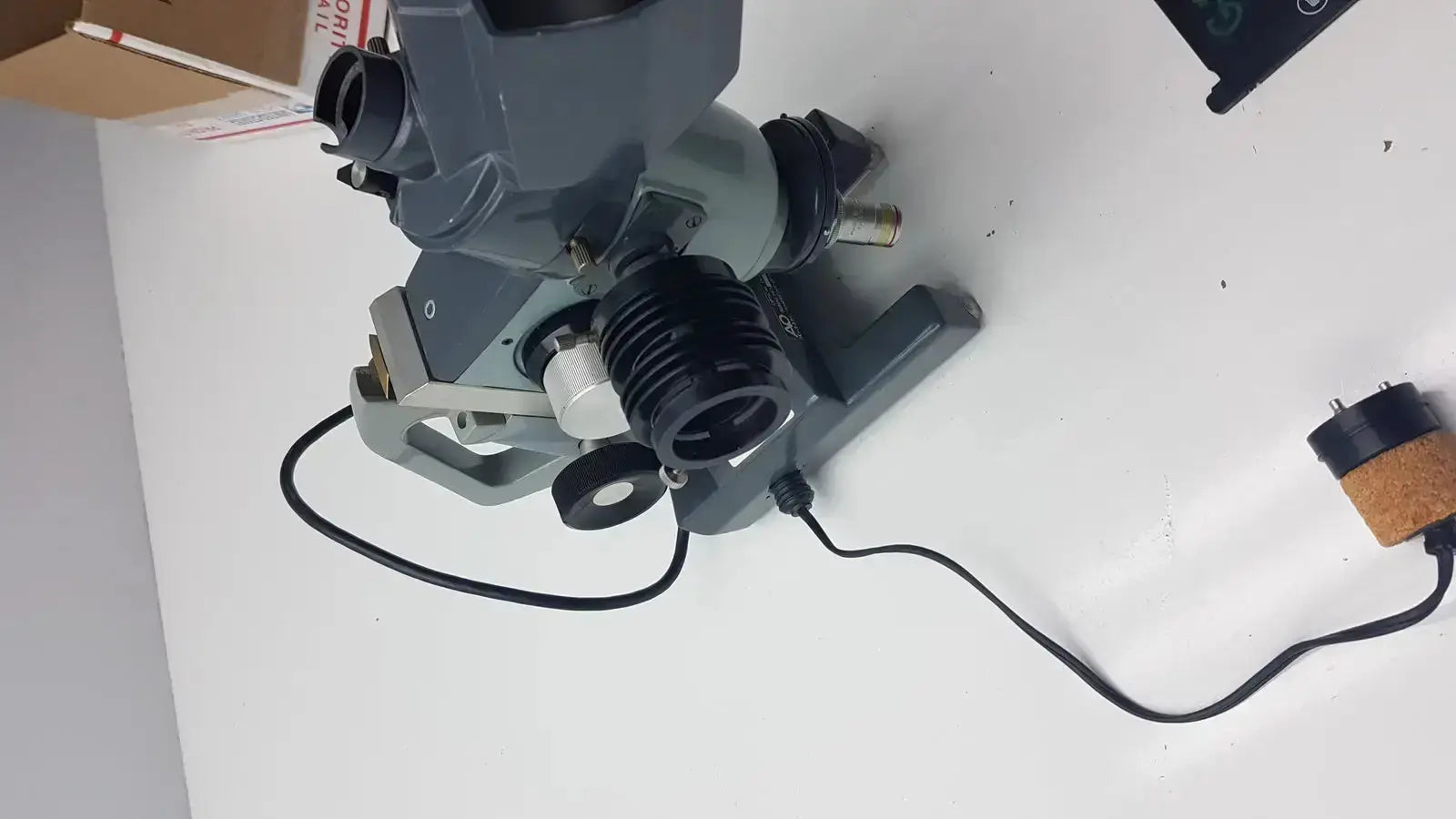 Gray and black American Optical AO Micro Star microscope with adjustable focus knobs and power cord for precise specimen viewing
