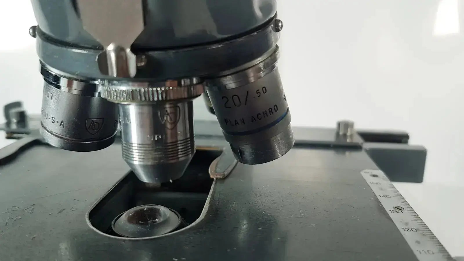 Black and silver american optical spencer compound microscope with labeled objective lenses for precise viewing