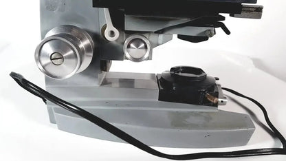 Silver metallic American Optical Spencer microscope with black accents and adjustable focus knobs for precise viewing