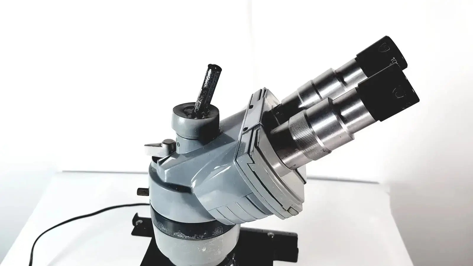 Gray and black american optical spencer microscope with dual eyepieces metallic body and adjustable focus knobs