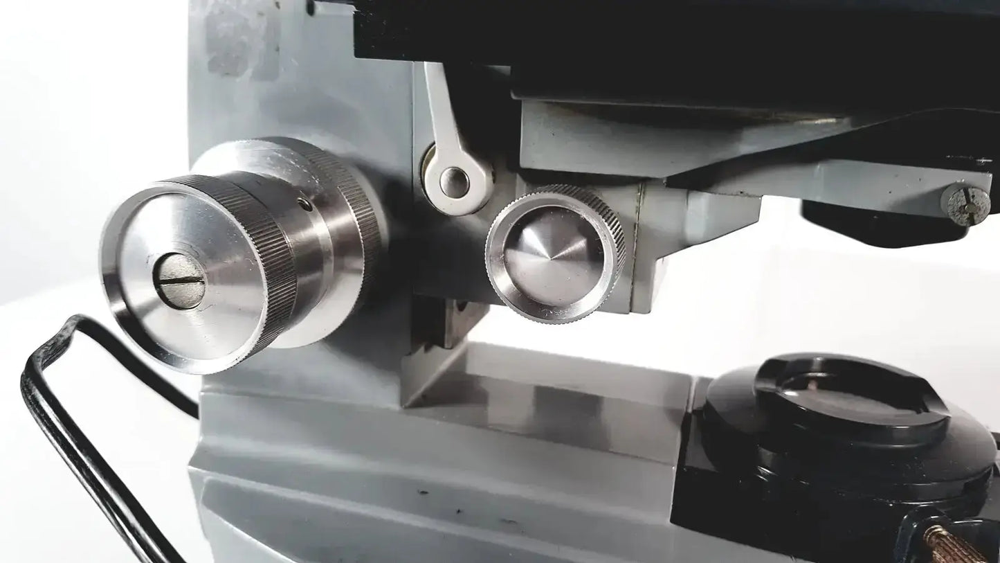 Silver metallic knurled focus knobs on an american optical spencer microscope for precise optical adjustments