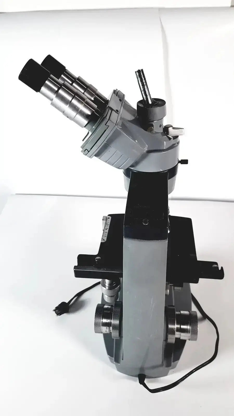 Gray and black american optical spencer microscope featuring dual eyepieces, metallic objectives, and a sturdy base