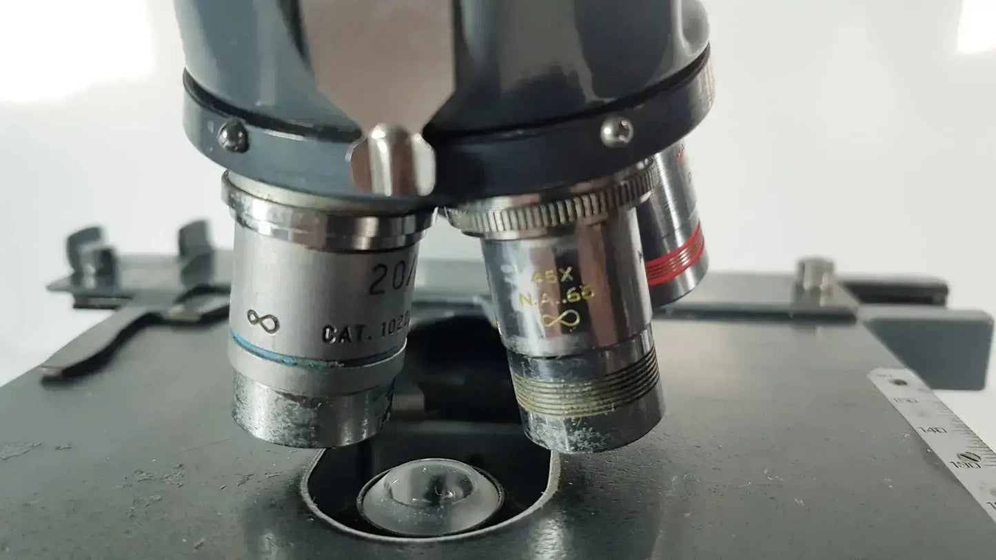 Black and silver american optical spencer microscope with labeled objective lenses for precise optical analysis