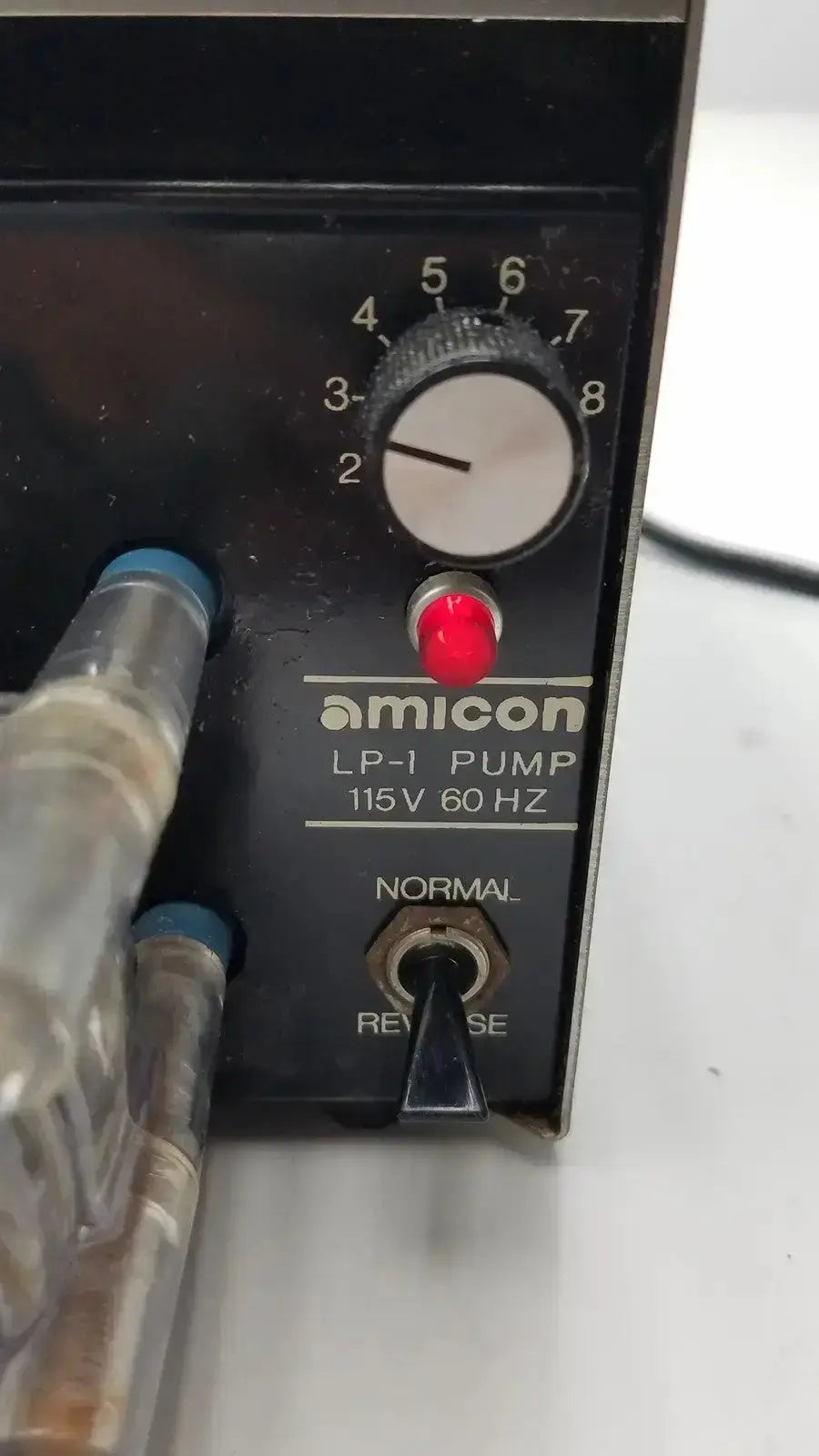 Black amicon lp-1 peristaltic pump with white dial red button and metallic tubing featuring cole parmer pump heads 7015