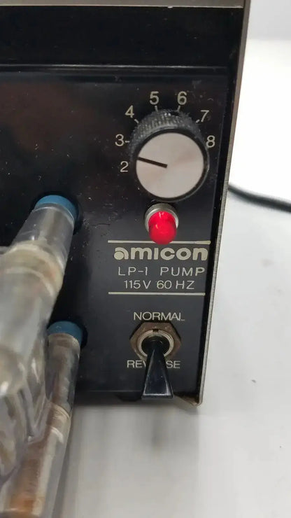 Black amicon lp-1 peristaltic pump with white dial red button and metallic tubing featuring cole parmer pump heads 7015