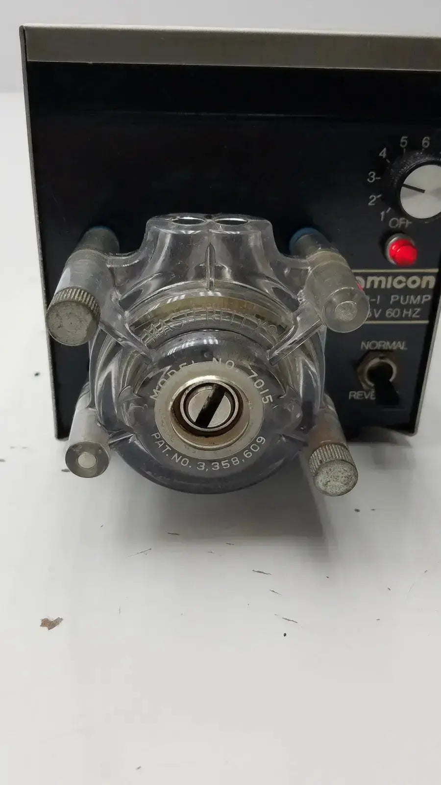 Clear plastic lp-1 peristaltic pump with metallic fittings and black comicon control panel for precise fluid handling