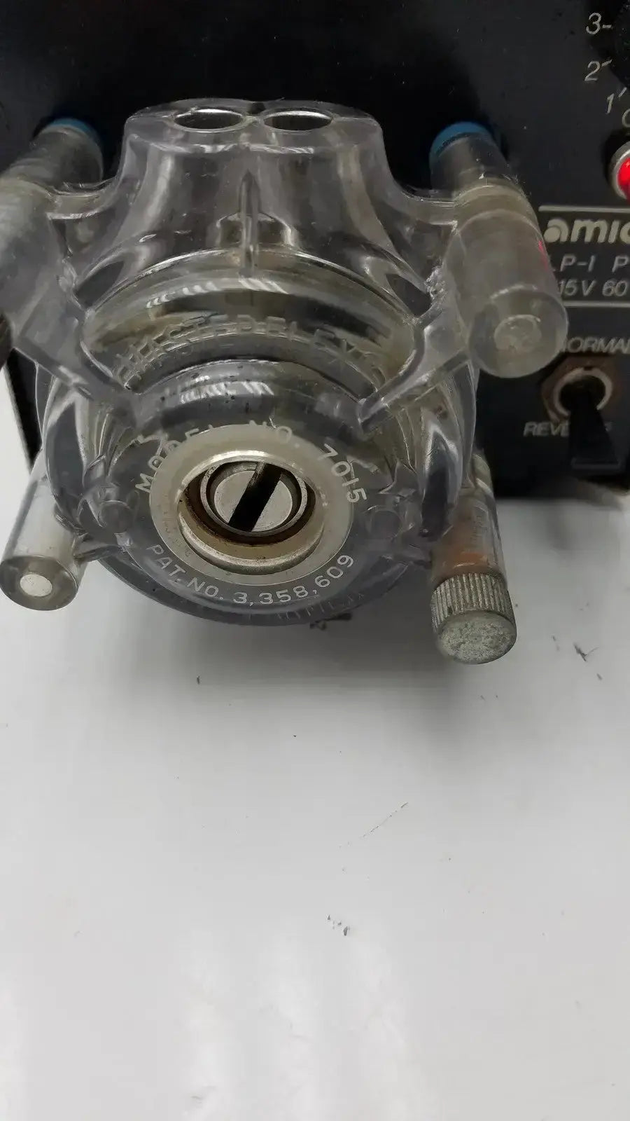 Clear plastic syringe pump head with metallic components and engraved markings for amicon model lp-1 peristaltic pump