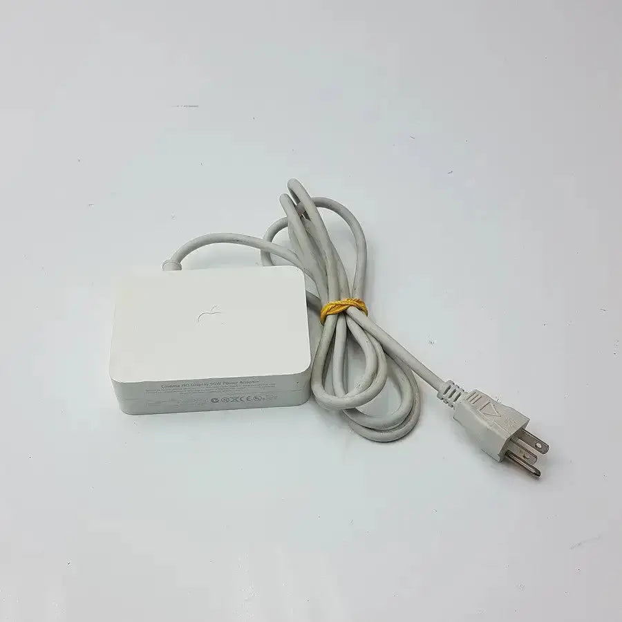 White Apple cinema HD display 90w power adapter with a coiled gray cable and yellow tie for MagSafe connection