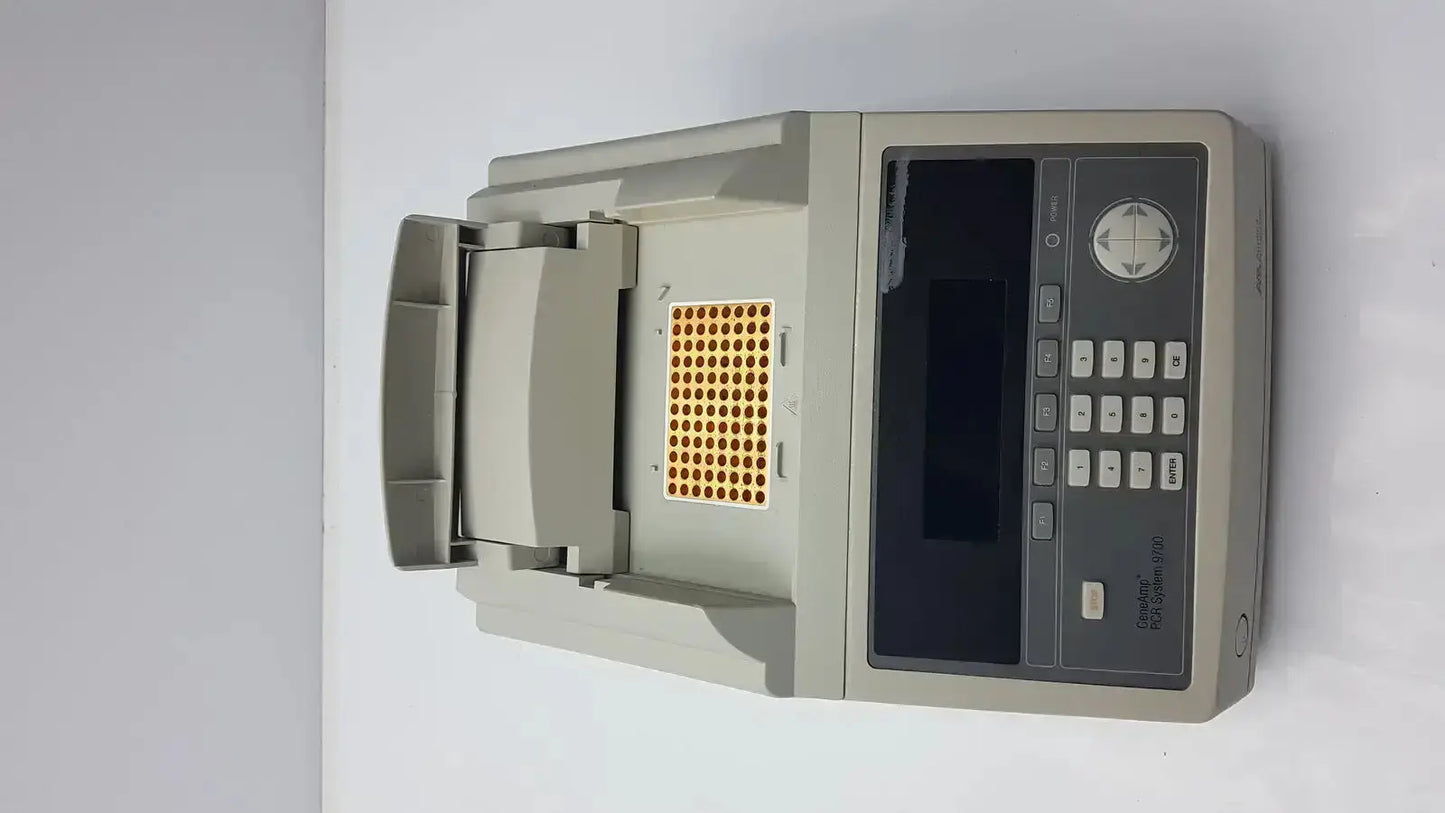 Gray applied biosystem geneamp pcr thermal cycler with digital display keypad and open compartment holding yellow microplate