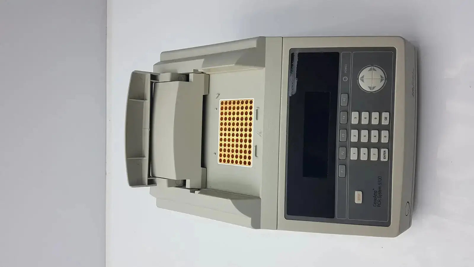 Gray applied biosystem geneamp pcr thermal cycler with digital display keypad and open compartment holding yellow microplate