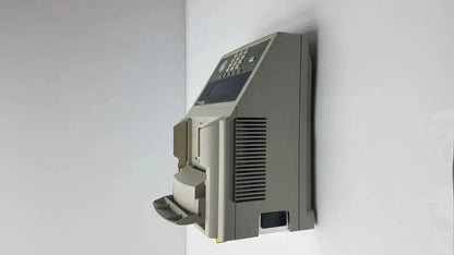 Gray plastic cash counting machine with keypad and bill slot alongside applied biosystem geneamp pcr thermal cycler