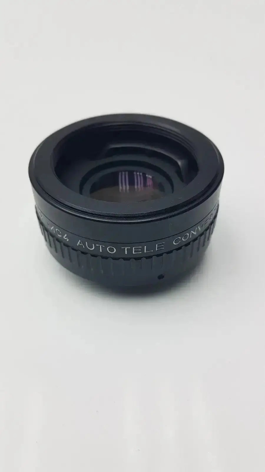 Black circular rokunar 2x mc4 auto tele converter lens adapter with engraved 4x auto tele text on textured ring