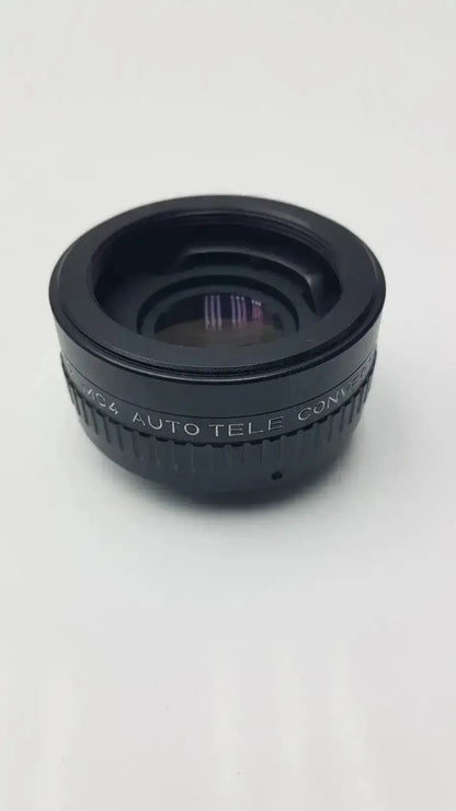 Black circular rokunar 2x mc4 auto tele converter lens adapter with engraved 4x auto tele text on textured ring