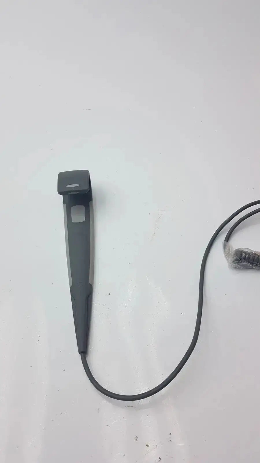Black plastic clip with coiled black cord attached to arjo huntleigh carendo 5 function remote for shower hygiene chair