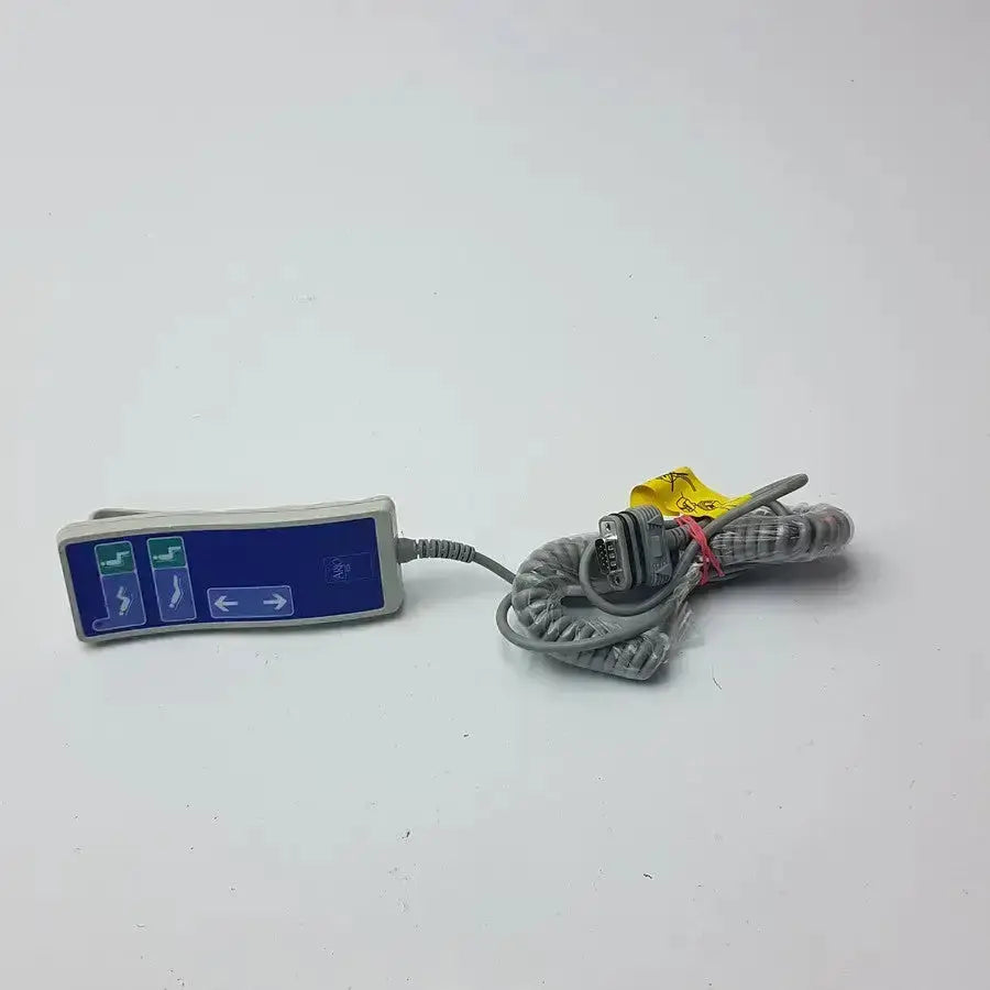 Gray arjo huntleigh patient lift remote handset with blue display and green buttons connected to coiled serial cable